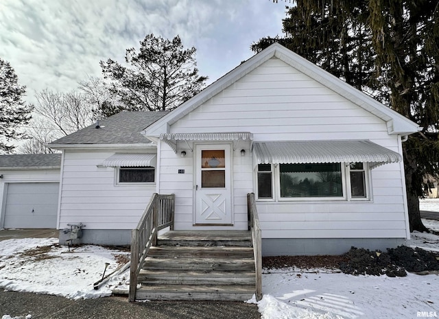 bungalow-style home featuring roof with shingles and an attached garage