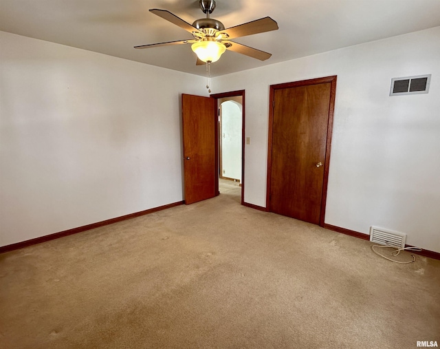 unfurnished bedroom with light carpet, baseboards, visible vents, and ceiling fan