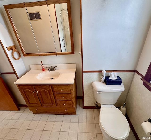 bathroom with toilet, tile patterned floors, visible vents, and vanity