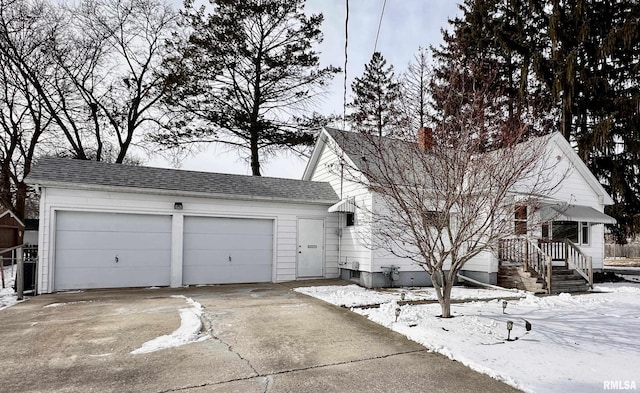 view of front of house featuring a shingled roof, concrete driveway, and an attached garage