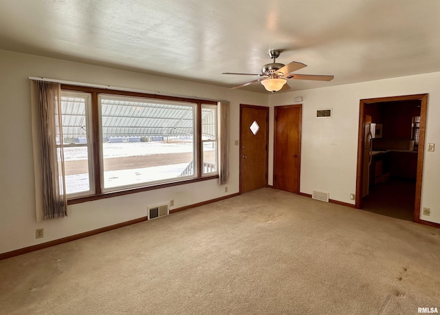 empty room featuring light colored carpet, visible vents, and plenty of natural light