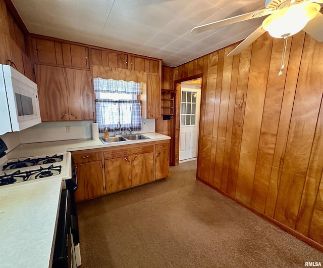 kitchen featuring light countertops, white microwave, a sink, and brown cabinets