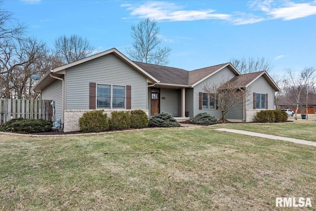 ranch-style home with brick siding, fence, and a front yard