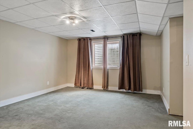 empty room with carpet floors, baseboards, and a drop ceiling