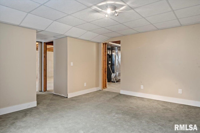 interior space featuring baseboards, a paneled ceiling, and light colored carpet