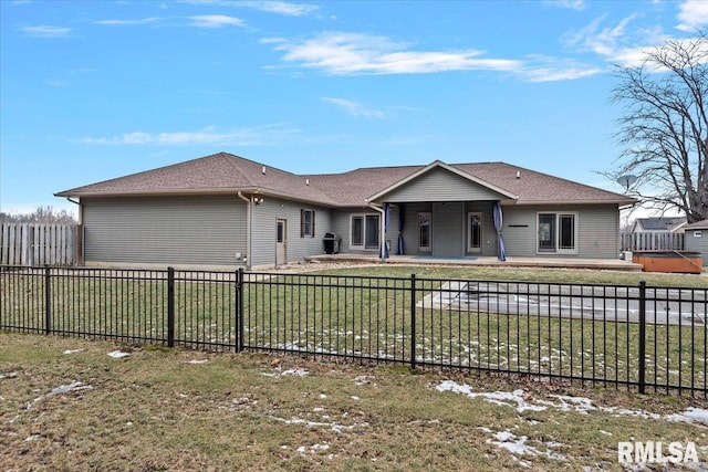 view of front of home with a hot tub, a patio area, a fenced backyard, and a front lawn