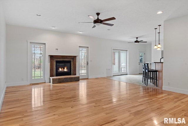 unfurnished living room featuring baseboards and light wood-style floors