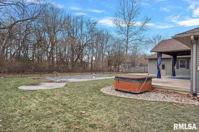 view of yard featuring fence, a hot tub, and a patio