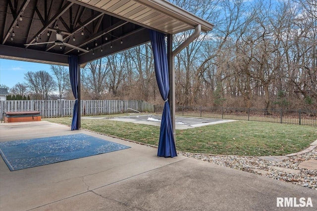 view of patio featuring a hot tub, ceiling fan, and a fenced backyard