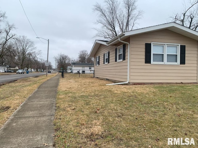 view of home's exterior with fence and a yard