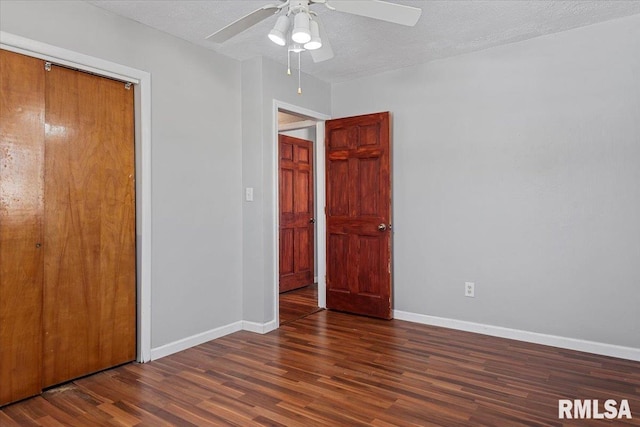 unfurnished bedroom with ceiling fan, a textured ceiling, baseboards, a closet, and dark wood-style floors