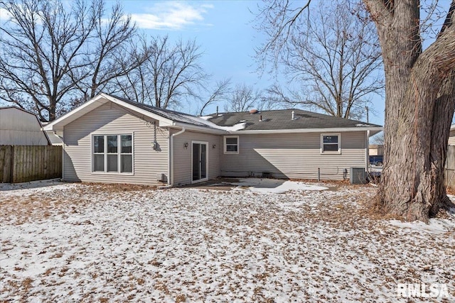 snow covered property featuring fence and cooling unit