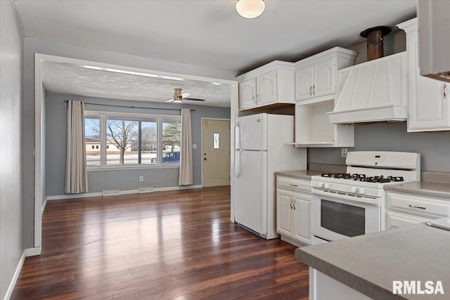 kitchen with dark wood-style floors, white appliances, white cabinetry, and custom range hood