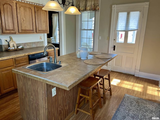 102 W Lorton St, Roodhouse, IL 62082 - kitchen with a sink, wood finished floors, brown cabinetry, and healthy amount of natural light