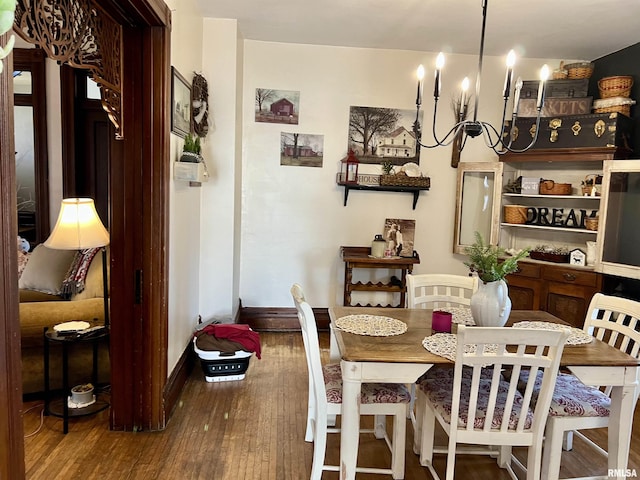 102 W Lorton St, Roodhouse, IL 62082 - dining space featuring wood finished floors, a chandelier, and baseboards