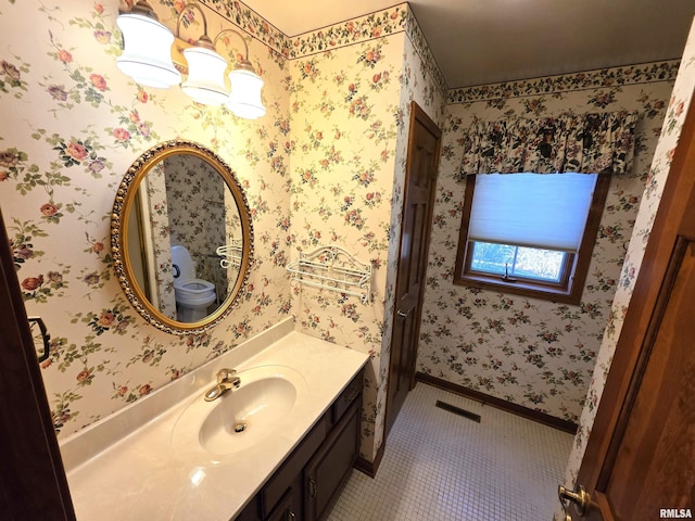 bathroom featuring tile patterned floors, vanity, baseboards, and wallpapered walls