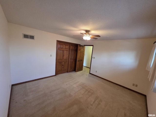 unfurnished bedroom with visible vents, a textured ceiling, and baseboards