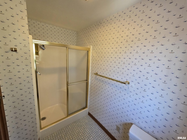 bathroom with a stall shower, tile patterned flooring, and wallpapered walls