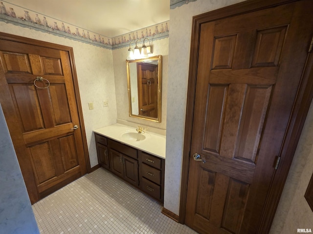 bathroom with baseboards, wallpapered walls, vanity, and tile patterned floors