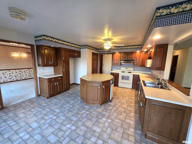 kitchen with white electric stove, a peninsula, light countertops, under cabinet range hood, and a sink