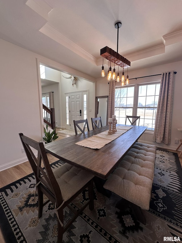 dining room featuring a wealth of natural light, a raised ceiling, and crown molding