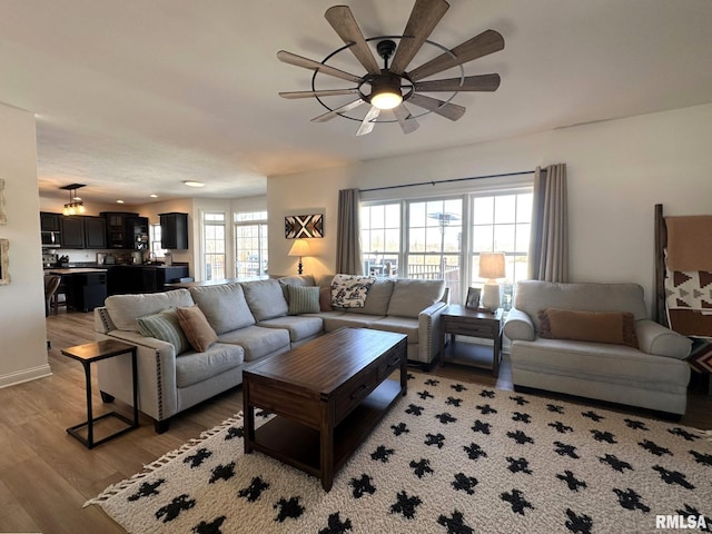 living room featuring light wood-style flooring and a ceiling fan