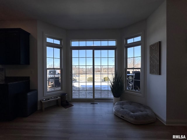 doorway to outside with baseboards and wood finished floors