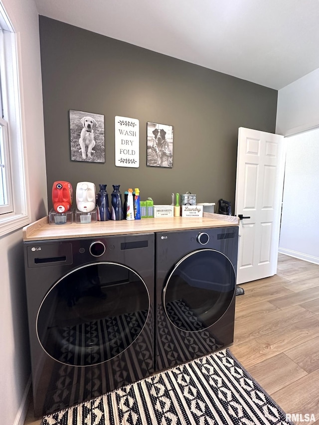 clothes washing area featuring laundry area, baseboards, light wood-style floors, and independent washer and dryer