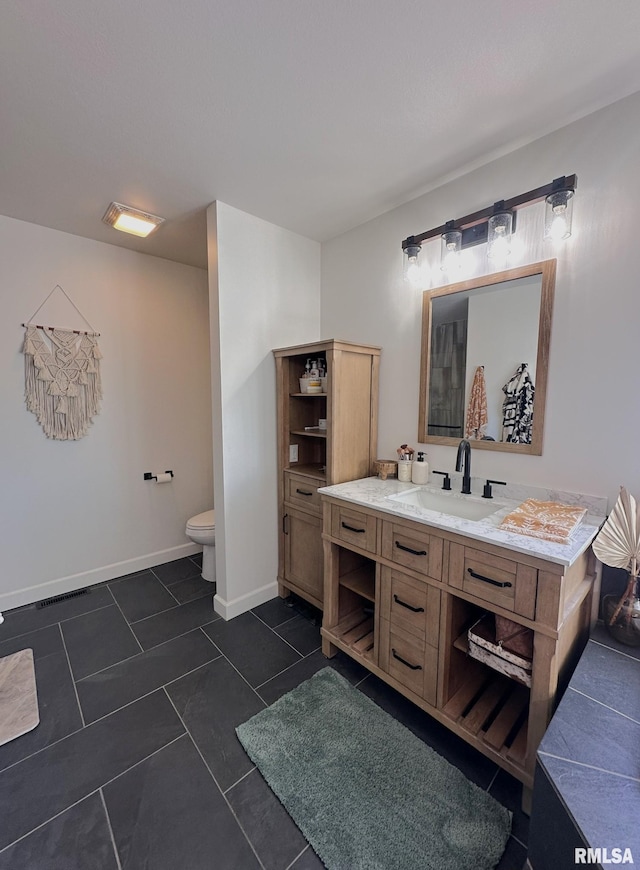 bathroom featuring visible vents, toilet, vanity, tile patterned flooring, and baseboards