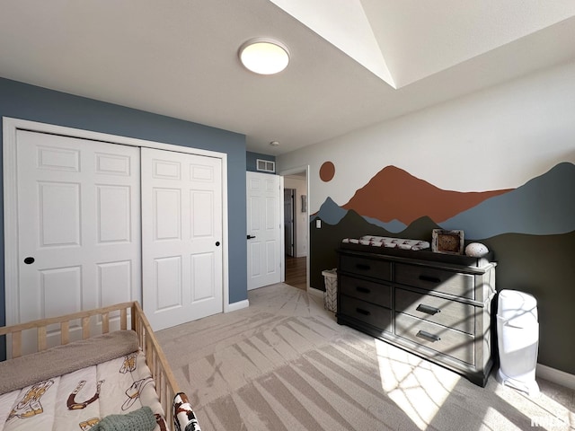 bedroom featuring baseboards, visible vents, a closet, and light colored carpet