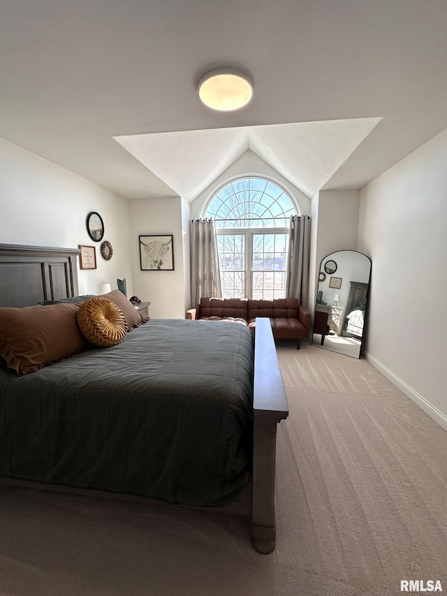 carpeted bedroom with lofted ceiling and baseboards