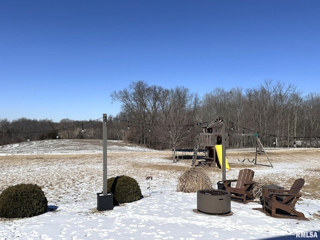 yard covered in snow featuring a fire pit and playground community