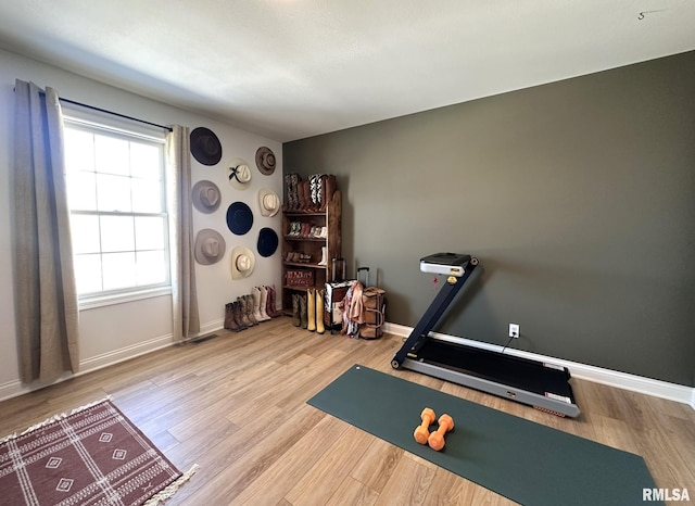 workout room with visible vents, baseboards, and wood finished floors