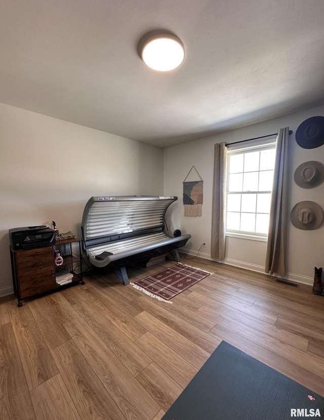 bedroom featuring wood finished floors, visible vents, and baseboards