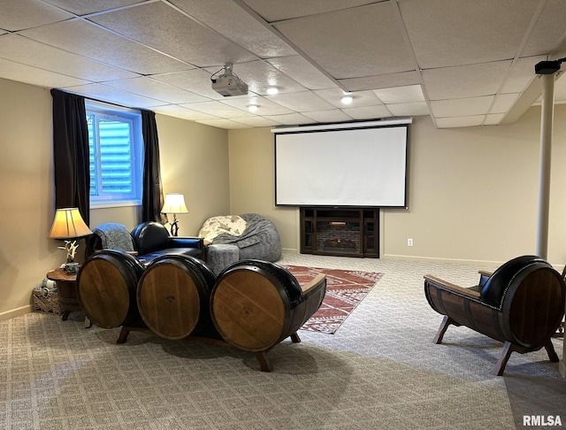 carpeted home theater featuring a fireplace, a paneled ceiling, and baseboards