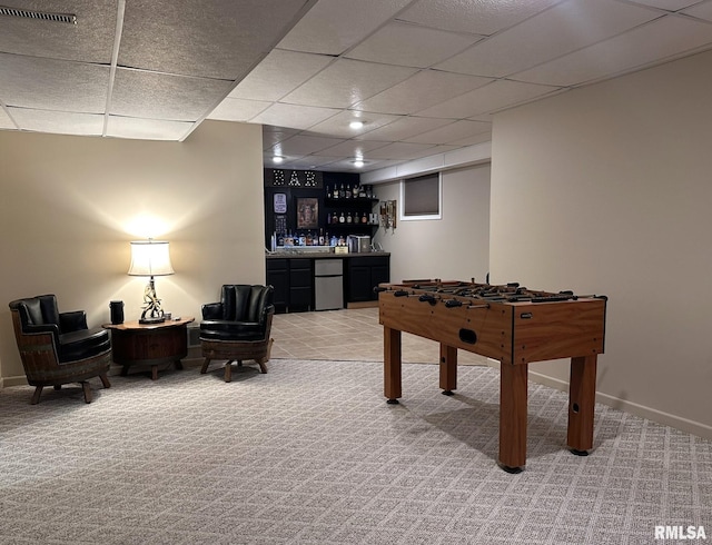 rec room with light carpet, a dry bar, baseboards, visible vents, and a paneled ceiling