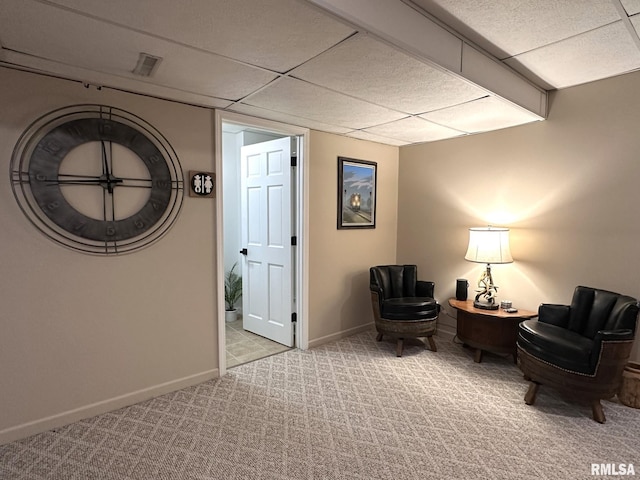 living area with carpet floors, visible vents, baseboards, and a drop ceiling