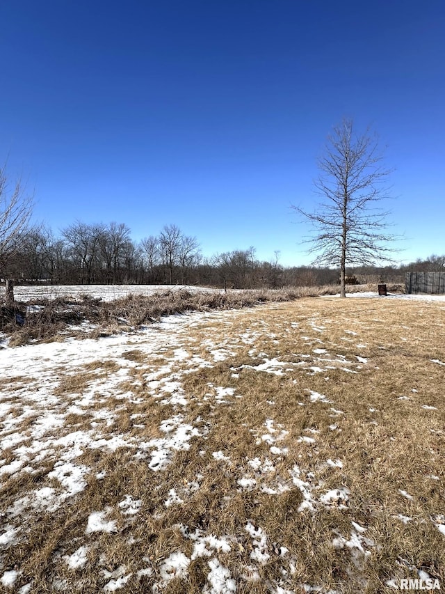 yard covered in snow featuring a rural view