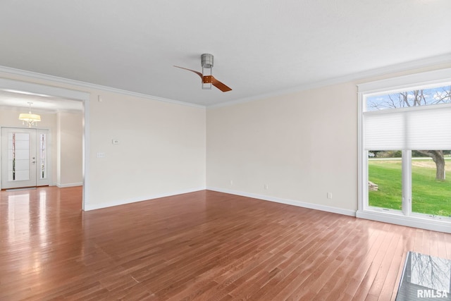 spare room featuring ornamental molding, ceiling fan, baseboards, and wood finished floors