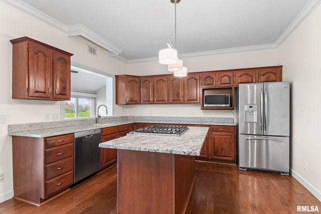 kitchen with appliances with stainless steel finishes, dark wood-style flooring, a kitchen island, and a sink