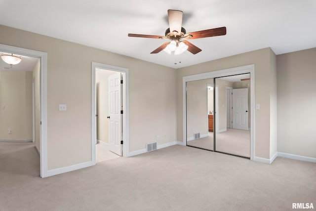 unfurnished bedroom with light colored carpet, a closet, visible vents, and baseboards