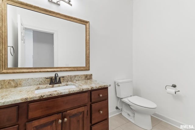 bathroom with baseboards, vanity, toilet, and tile patterned floors