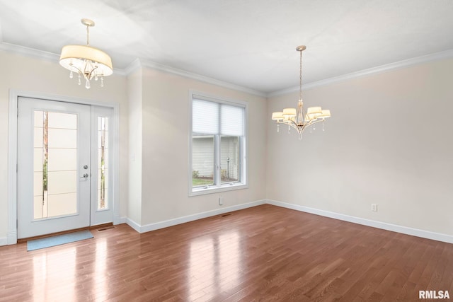 entrance foyer featuring a chandelier, wood finished floors, and crown molding