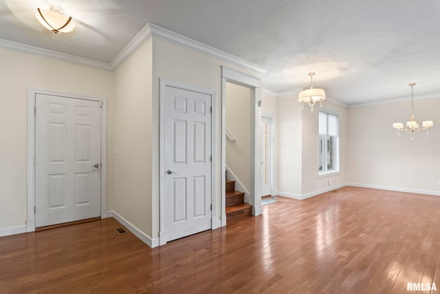 unfurnished room with dark wood-style floors, baseboards, a chandelier, and crown molding