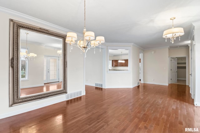 unfurnished dining area with visible vents, a notable chandelier, and wood finished floors