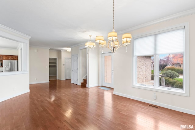 interior space featuring ornamental molding, baseboards, and wood finished floors