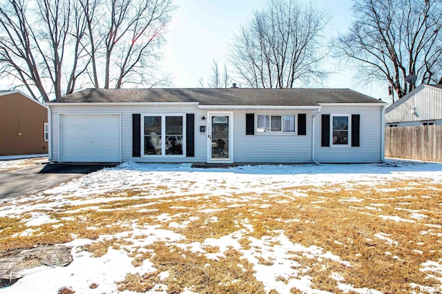 ranch-style house featuring aphalt driveway, an attached garage, and fence