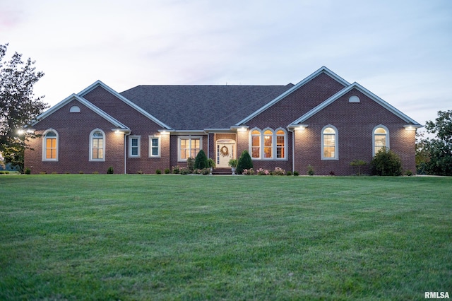 view of front of home with brick siding and a front lawn