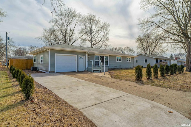 ranch-style home with a garage, driveway, and central AC unit