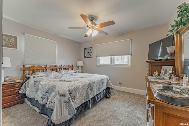 bedroom with light carpet, ceiling fan, and baseboards